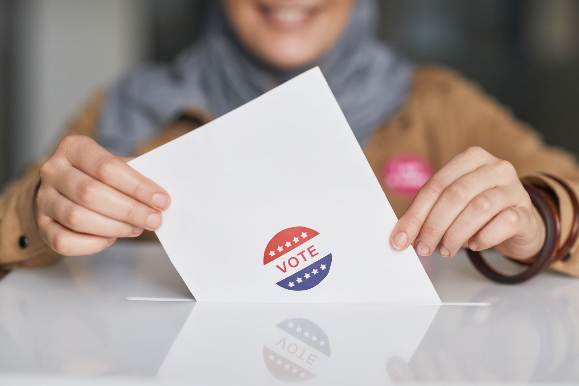 Mãos segurando cédula de votação em close