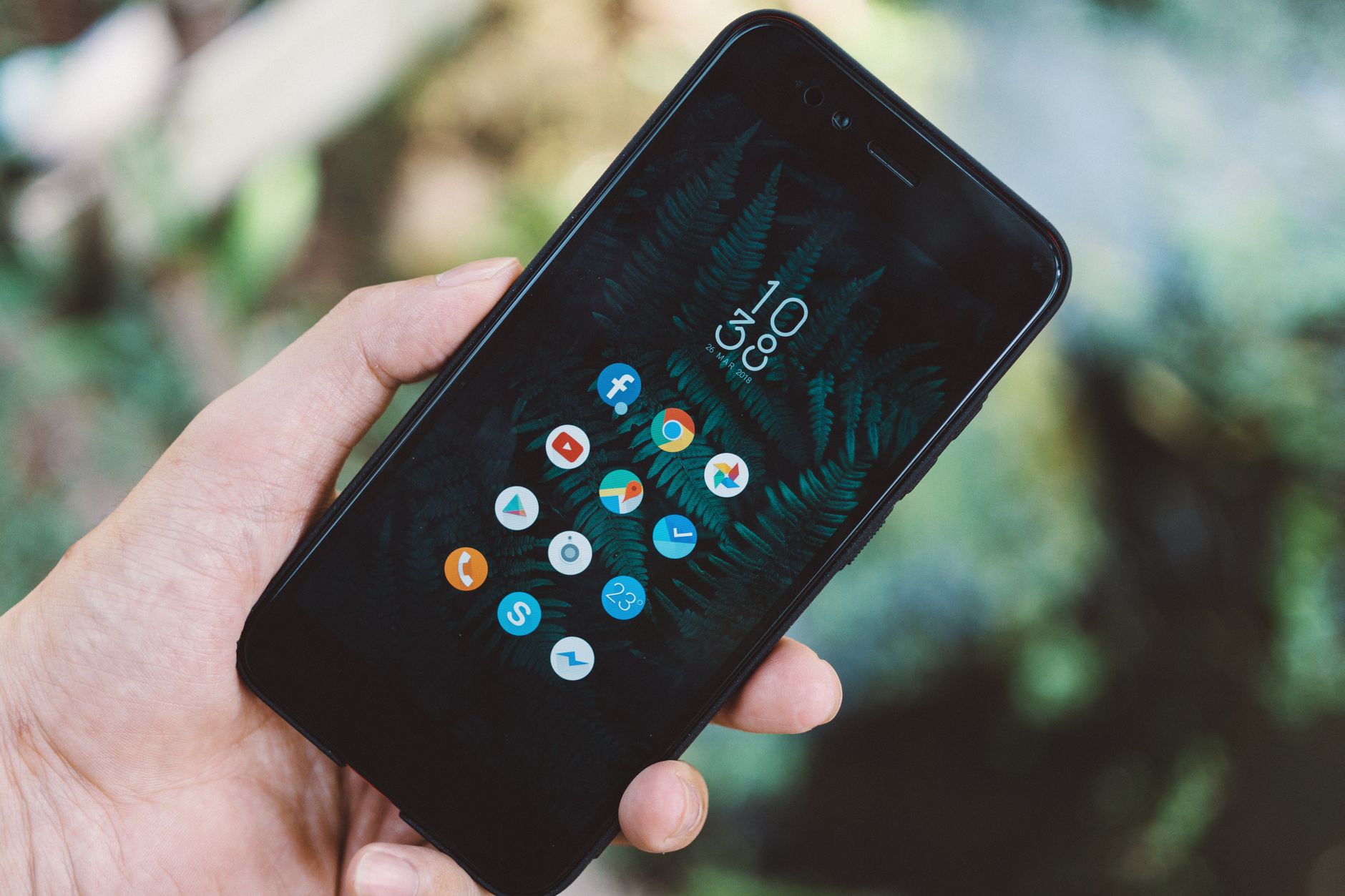 Mão segurando smartphone com ícones de aplicativos
